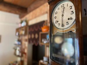 a wooden clock is hanging on a wall at おとまち 甘藍 Otomachi Kanran in Kure