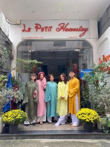 un grupo de personas de pie en frente de una tienda en Le Petit Homestay en Hue