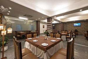 a dining room with a table and chairs at Luxury Tashree Hotel at Airport in New Delhi