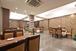 a dining room with tables and chairs in a restaurant at Luxury Tashree Hotel at Airport in New Delhi