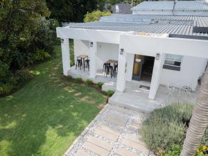 Elle offre une vue aérienne sur une maison blanche dotée d'une terrasse. dans l'établissement Kelkiewyn Waterkloof Guesthouse, à Pretoria
