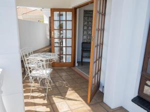 Habitación con balcón con mesa y sillas. en Kelkiewyn Waterkloof Guesthouse, en Pretoria