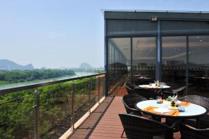 Sheraton Guilin Hotel في قويلين: مطعم على طاولات وكراسي على شرفة
