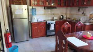 uma cozinha com um frigorífico branco e uma mesa com uma mesa em Hundred Islands Guest House em Alaminos