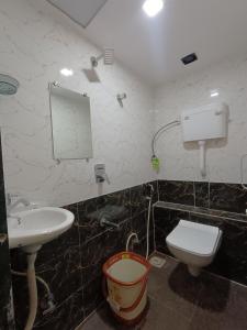 a bathroom with a sink and a toilet and a mirror at Hotel Powai Residency in Mumbai