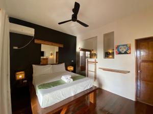 een slaapkamer met een bed en een plafondventilator bij Happiness Boutique Resort in El Nido