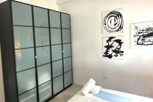 a bedroom with a large glass cabinet in it at KASA The Lofts 305 in San Juan