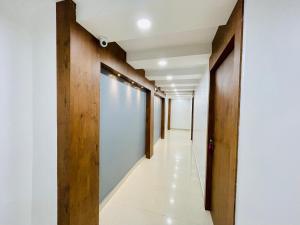 einen Flur in einem Gebäude mit Holztüren und Flur in der Unterkunft Hotel Nandan Inn in Gaya