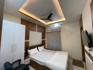 Habitación pequeña con cama y ventilador de techo. en Hotel Nandan Inn, en Gaya
