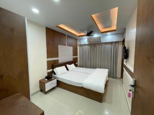 ein Schlafzimmer mit einem Bett und einem TV in der Unterkunft Hotel Nandan Inn in Gaya