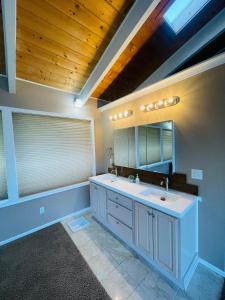 y baño con lavabo y espejo. en Lake Tapps Dock House on the Bankers Island, 