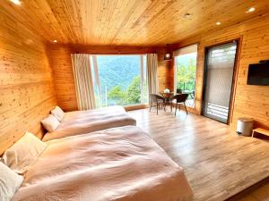 1 dormitorio con 2 camas en una habitación con mesa en No. 36 Farm, en Hualing