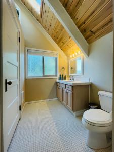 y baño con aseo y lavamanos. en Lake Tapps Dock House on the Bankers Island, 