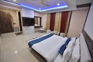 a bedroom with a large white bed and a television at Hotel Himalaya in Bongaigaon