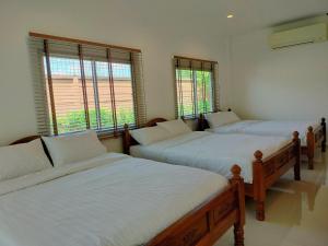 a room with three beds with white sheets and windows at Private house Casa seaside Rayong in Ban Chak Phai