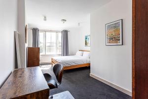 - une chambre avec un lit, un bureau et une table dans l'établissement Contemporary Open Plan Penthouse, à Londres