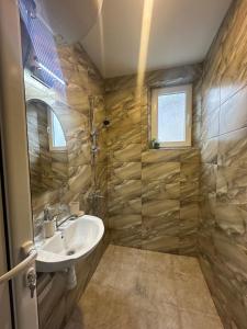 a bathroom with a sink and a shower at VELI HOUSE VELINGRAD/ ВелиХаус Къща за гости Велинград in Velingrad