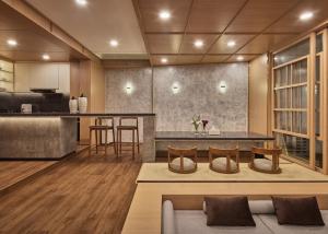 a kitchen and living room with a table and chairs at Yama Onsen Villa in Bandung