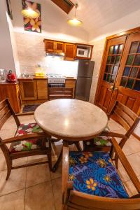 uma cozinha com uma mesa e algumas cadeiras e uma mesa em Heimanarii,slodge 0puhi em Haapiti