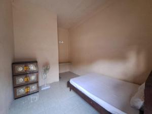 a small bedroom with a bed and a dresser at SPOT ON 93465 Archa Guest House Syariah in Jambi