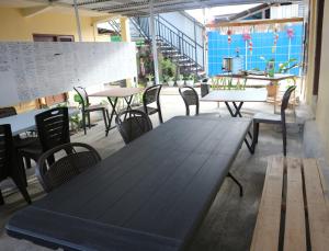 Tange Guest House في روتينج: طاولة خشبية مع كراسي وطاولات في مطعم