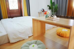 um quarto com uma cama e uma mesa com duas almofadas em Banyan Bay Homestay, Meizhou Island em Meizhou