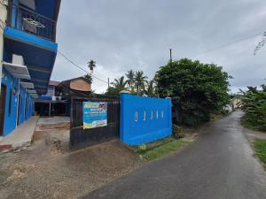 a blue fence on the side of a street at SPOT ON 93465 Archa Guest House Syariah in Jambi