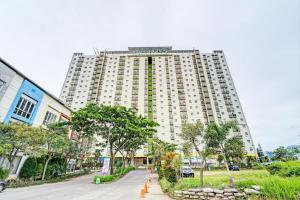 een hoog wit gebouw met een straat ervoor bij OYO 93426 Metro Suites Apartment By Goodvibes in Bandung
