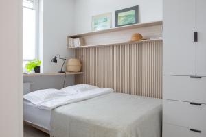 małą sypialnię z łóżkiem i półkami w obiekcie Apartament Redłowska Kępa nad Morzem w mieście Gdynia