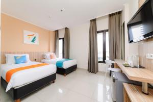 Habitación de hotel con 2 camas y TV de pantalla plana. en Sans Hotel Green Bekasi by RedDoorz, en Bekasi