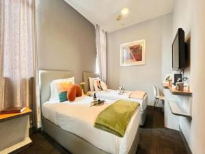 クアラルンプールにあるSwing & Pillows - KL Sg Besi formerly known as U Pac Hotelのベッドとテレビが備わるホテルルームです。