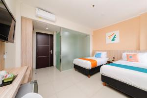 勿加泗的住宿－Sans Hotel Green Bekasi by RedDoorz，酒店客房设有两张床和电视。