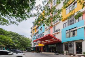 un edificio con una fachada colorida en una calle en Sans Hotel Green Bekasi by RedDoorz, en Bekasi