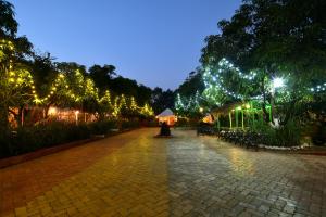 a walkway with christmas lights in a park at night at Gir Pride Resort in Sasan Gir