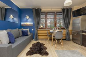 a blue living room with a gray couch and a table at Rent like home - Comfortable Studio Sapiezynska in Warsaw