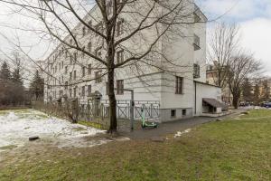 a white building with a tree in front of it at Rent like home - Comfortable Studio Sapiezynska in Warsaw