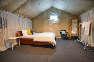 ダージリンにあるDharti The Glamping Havenのテント内のベッド1台が備わるベッドルーム1室