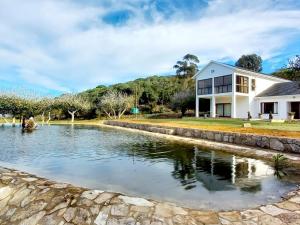 a house with a pond in front of a house at Hoekland Manor Stilbaai in Stilbaai