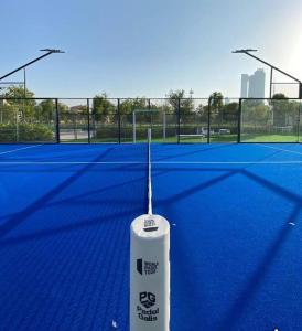 a tennis racket on a tennis court at Karen's Studio in corniche Abu Dhabi behind Shikha Fatima park in Abu Dhabi