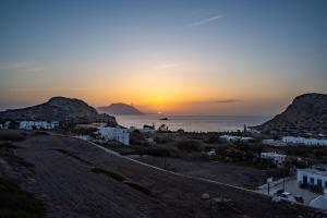 a sunset over a town and the ocean at Arkasa Palace in Arkasa