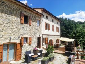 a stone house with a patio in front of it at Le Ginestre Guesthouse Assisi in Assisi