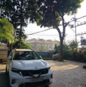 een witte auto geparkeerd aan de kant van een straat bij Hotel Prabhu Krupa, Bhubaneswar in Bhubaneshwar