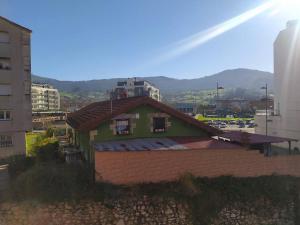 a green house with a roof in a city at Apartamento en Astillero con plaza de aparcamiento in El Astillero