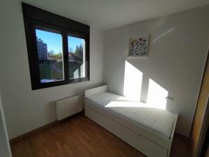 a small white room with a window and a bed at Apartamento en Astillero con plaza de aparcamiento in El Astillero