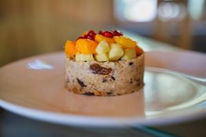 a piece of cake with fruit on a white plate at Dharti The Glamping Haven in Darjeeling