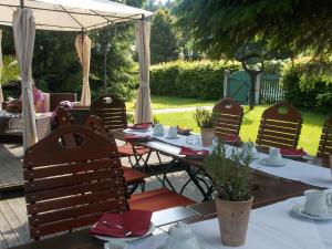 un conjunto de mesas y sillas bajo una sombrilla en Romantik Hotel Zum Lindengarten en Kurort Jonsdorf