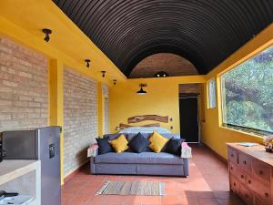 a room with a couch on a patio at La Cabaña Negra al fondo del Bosque de Tepoztlán in Tepoztlán