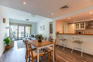 a kitchen and living room with a table and chairs at Serene & Spacious 1BR The Greens in Dubai