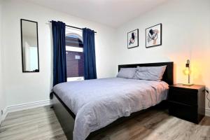 een slaapkamer met een groot bed en een raam bij Luxury home by Tim Hortons Field in Hamilton