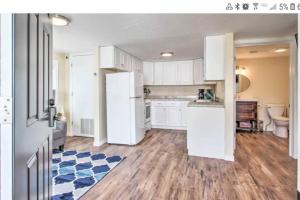 a kitchen with white cabinets and a refrigerator at Tranquil Cottage Walk Downtown in Great Falls